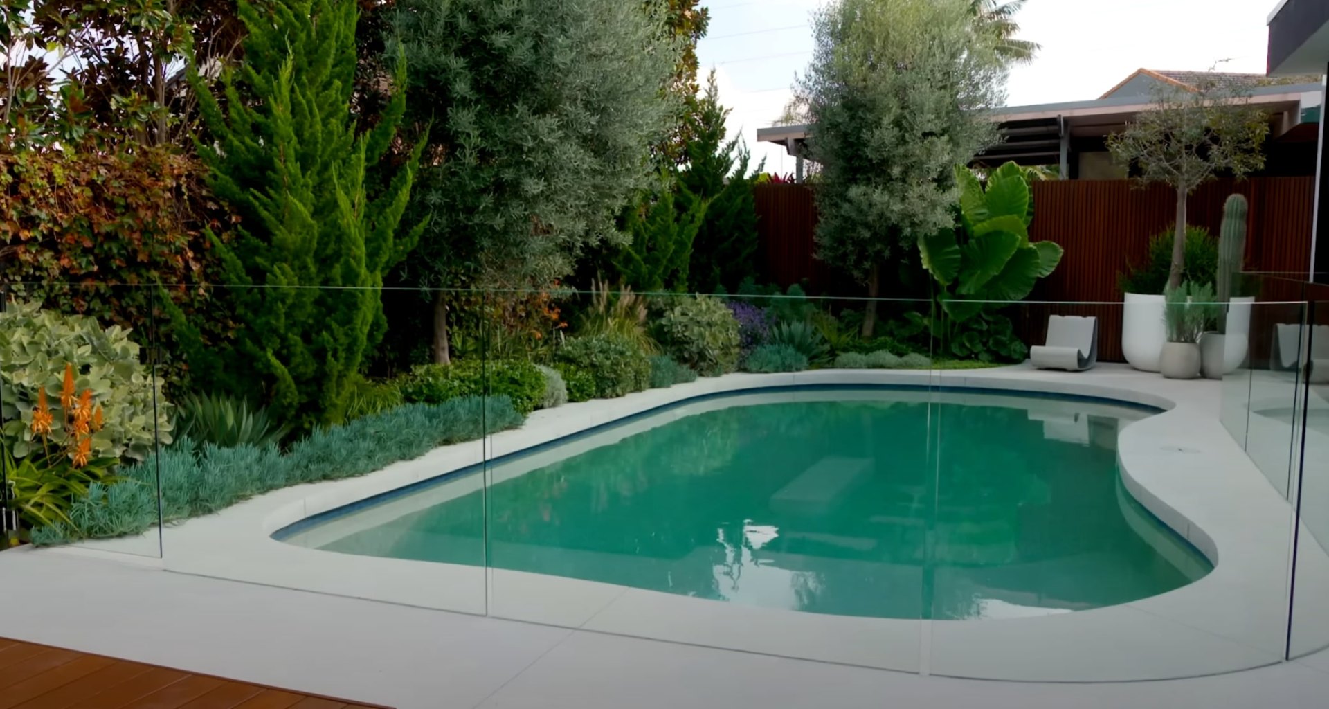 Low maintenance landscaping design with drought-resistant plants and elegant hardscaping Modern pool landscape with diverse plant varieties and professional hardscaping features